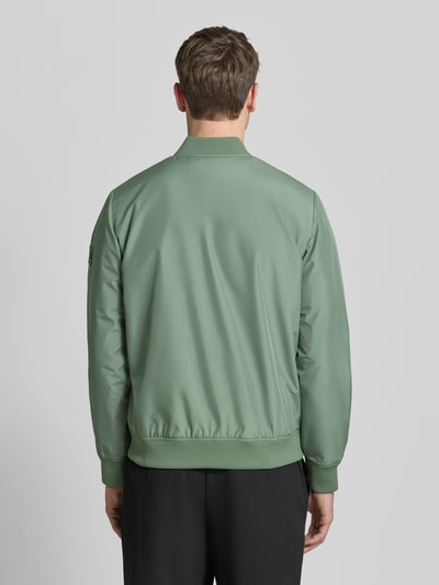 Männermodel trägt Jacke mit Stehkragen Modell 'clay' von Matinique in lichtgroen, regular fit, ritssluiting, steekzakken met drukknoopsluiting, ruglengte maat M 67 cm, schouderbreedte 45 cm, borstwijdte 56 cm, mouwlengte 66 cm. Ganzkörperansicht Rückansicht.