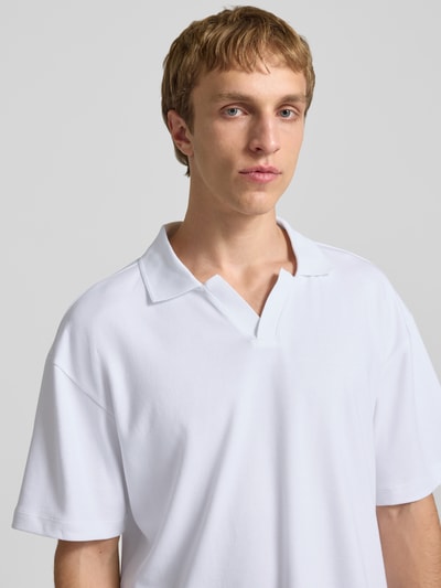 Männermodel trägt Boxy Fit Poloshirt aus Baumwoll-Mix Modell 'CASPIAN AIRLEX' von Only & Sons, unifarben weiß, Nahaufnahme Oberkörper.