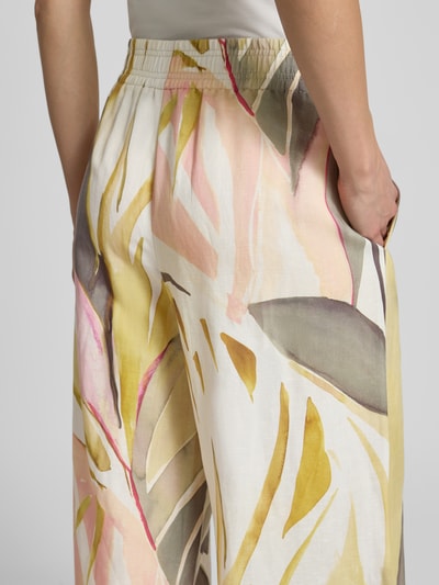 Männermodel trägt spodnie materiałowe z szerokimi nogawkami we wzór na całej powierzchni Wide Leg Stoffhose im Allover-Look Modell 'LIZETT' von Raffaello Rossi, elastyczny pas, szerokość w rozmiarze 36: 40 cm, długość wewnętrzna nogawki w rozmiarze 36: 74 cm, detaliczne ujęcie tyłu