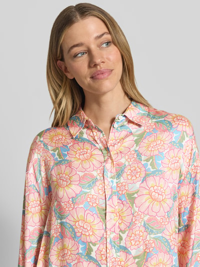 Modelka kobieca nosi Regular Fit Bluse aus Viskose im Allover-Look od Rich & Royal, kolorowy wzór kwiatowy, krój regular fit, czysta wiskoza, wykończenie koszulowe, zapięcie na guziki, długość tyłu 64 cm, długość rękawa 49 cm, ujęcie z przodu, zbliżenie na górną część ciała.