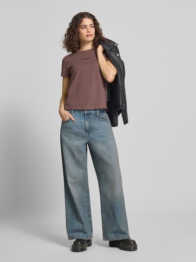 Frauenmodel trägt T-Shirt mit Rundhalsausschnitt und Logo-Stitching von Review, körpernah, Baumwoll-Mix, braun, Ganzkörperansicht von vorne.