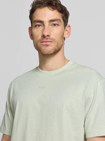 Männermodel trägt Regular Fit T-Shirt aus reiner Baumwolle Modell 'DAPOLINO' von HUGO, Optik: Unifarben, Label-Schriftzug, Nahaufnahme Oberkörper
