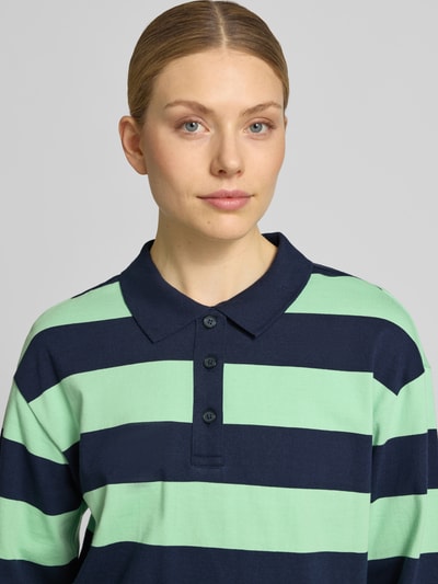 Modelka kobieca ma na sobie Loose Fit Poloshirt aus reiner Baumwolle od s.Oliver RED LABEL, miękka bawełna, paski, kołnierzyk polo, zbliżenie na górę ciała