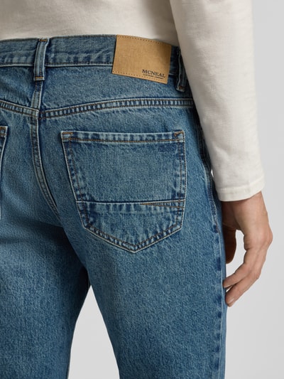 Männermodel trägt Loose Fit Jeans im 5-Pocket-Design von MCNEAL aus reiner Baumwolle in mittelblau, Detailaufnahme Gesäßbereich.