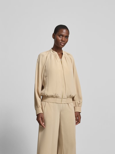 Frauenmodel trägt Blouson mit Reißverschluss von Joseph aus Material-Mix in Beige, lockere Passform, Stehkragen, Eingrifftaschen, Ganzkörperansicht von vorne. Rückenlänge 60 cm, Brustweite 40 cm, Ärmellänge 62 cm bei Größe 36.