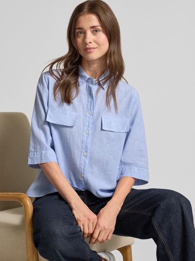 Frauenmodel trägt Bluse aus Leinen-Mix mit Brusttaschen Modell 'BEA' von 0039 Italy, 3/4-Arm, Loose-Fit, Hemdblusenkragen, Nahaufnahme Oberkörper.