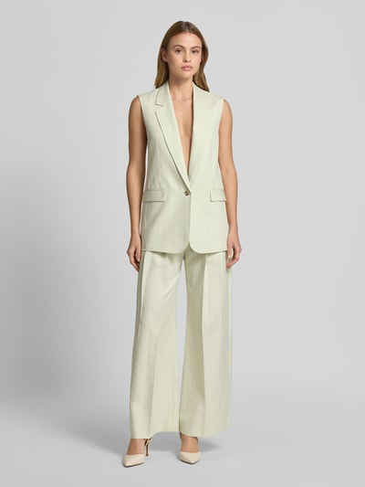Frauenmodel trägt Regular Fit Anzugweste mit Leinen-Anteil Modell 'JAKILY' von BOSS Orange im Nadelstreifen-Muster, Blazer-Optik mit Reverskragen, V-Ausschnitt, 1-Knopf-Verschluss und Pattentaschen, gefertigt in Twill aus Lyocell-Baumwoll-Leinen-Mix, helle Farbe, Ganzkörperansicht von vorne.