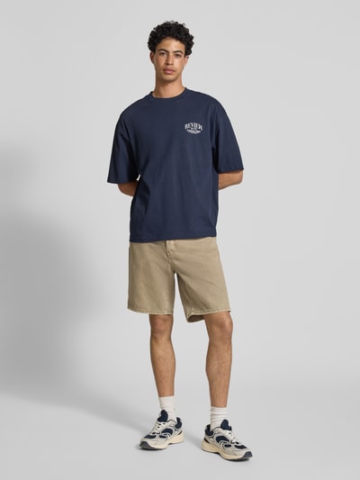 Männermodel trägt Regular Fit Jeansshorts aus reiner Baumwolle Modell 'EDGE' von Only & Sons in Denim-Optik, 5-Pocket-Design, Ganzkörperansicht von vorne.