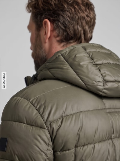 Männermodel trägt Regular Fit Steppjacke mit Storm Cuffs Modell 'BAVENO' von Strellson in Oliv, glänzend, Detailaufnahme Rückansicht, KI-modifiziertes Bild.