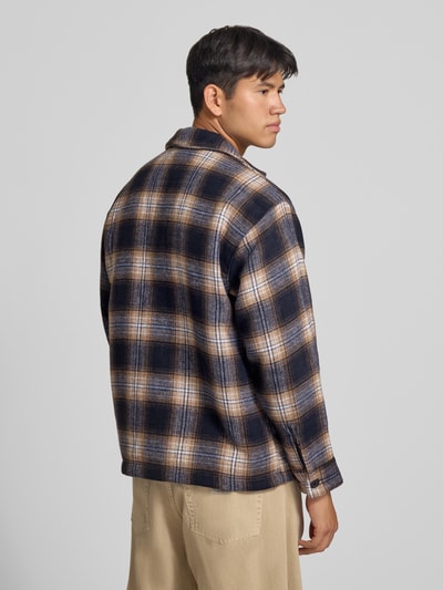 Männermodel trägt Regular Fit Hemdjacke mit Brusttasche Modell 'SOHO OLLIE' von JACK & JONES, kariert, Ganzkörperansicht Rückansicht.