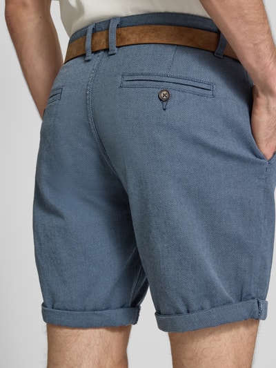 Männermodel trägt Bermudas mit Gürtel und Eingrifftaschen Modell 'NEBRASKA' von Redefined Rebel, Blau, Baumwoll-Mix mit Stretch-Anteil, Ganzkörperansicht Rückansicht.