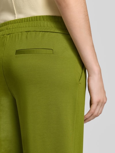 Frauenmodel trägt Wide Fit Hose mit Viskose-Anteil Modell 'Kate' von ICHI in Grün, elastischer Bund, Detailaufnahme, KI-modifiziertes Bild.