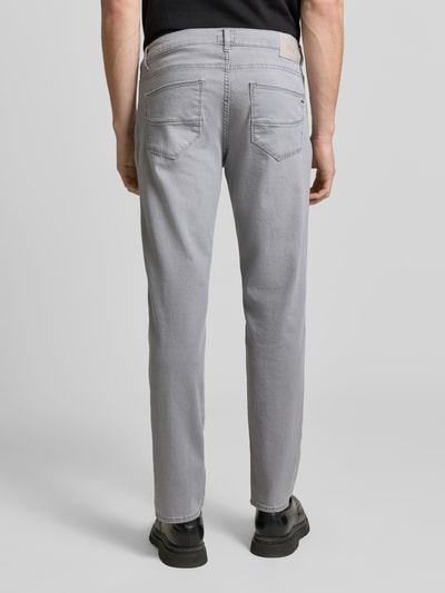 Männermodel trägt Sraight Fit Jeans mit Eingrifftaschen Modell 'Cadiz' von Brax in Grau, Used-Look, Baumwoll-Elasthan-Mix, Ganzkörperansicht Rückansicht.