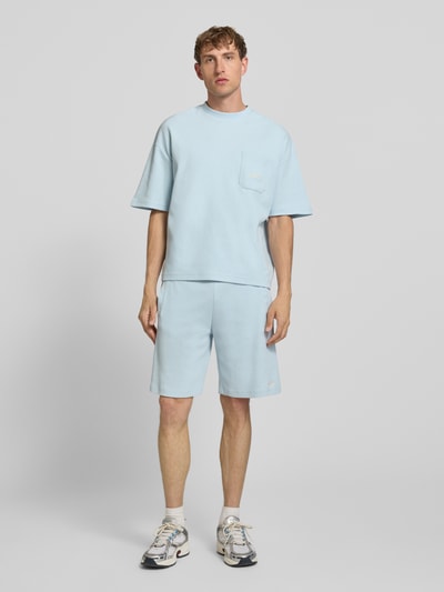 Männermodel trägt T-Shirt mit Strukturmuster und Label-Stitching von PROHIBITED in Hellblau aus Reine Baumwolle, Regular-Fit, Rundhalsausschnitt, Brusttasche, Rückenlänge 64 cm bei Größe M, Ganzkörperansicht von vorne.