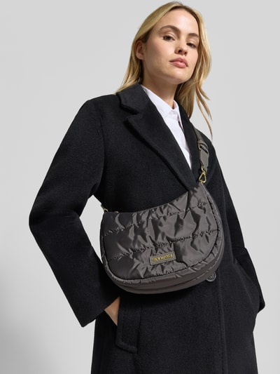 Frauenmodel trägt schwarze Jacke und graue Handtasche mit Label-Detail Modell 'Lifetime Buddy S' von Hey Marly, Steppnähte, Hauptfach mit Reißverschluss, Schulterriemen, Ganzkörperansicht von vorne.