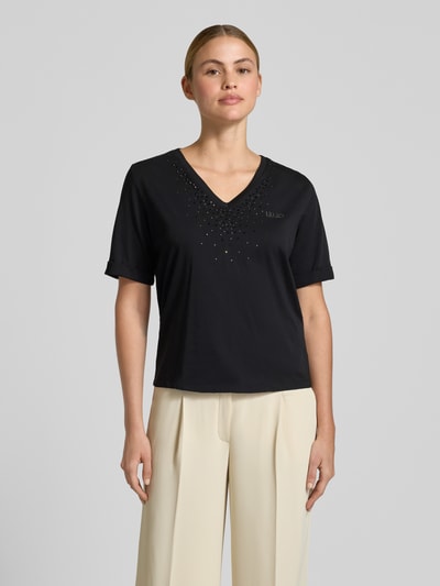 Frauenmodel trägt T-Shirt mit Strasssteinbesatz und V-Ausschnitt von LIU JO SPORT in Schwarz, Baumwolle, gerader Schnitt, Nahaufnahme Oberkörper.