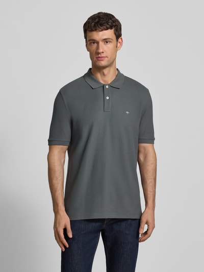 Männermodel trägt Regular Fit Poloshirt mit Label-Stitching von Fynch-Hatton in Reine Baumwolle mit Polokragen, kurze Knopfleiste, Ganzkörperansicht von vorne.