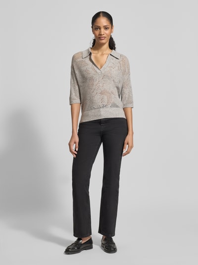 Modelka nosi Relaxed Fit Pullover aus Escorial Woll-Mix mit Kaschmir-Anteil od HERZENS, damski sweter, jasnoszary melanż, dzianina, półrękaw, kołnierzyk, dekolt V, ażurowy wzór, elastyczne wykończenia, długość tyłu w rozmiarze 36: 55 cm, długość rękawa: 23 cm, widok całej sylwetki od przodu.