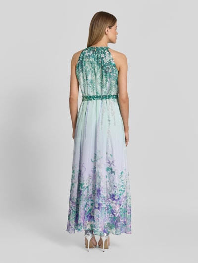 Frauenmodel trägt Maxikleid mit Bindegürtel von Marc Cain im floralen Allover-Look, A-Linie, Neckholder, Rückenlänge 145 cm, Brustweite 58 cm, Ganzkörperansicht Rückansicht.