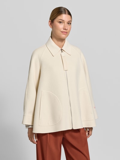 Frauenmodel trägt Relaxed Fit Kurzmantel aus reiner Schurwolle Modell 'MCOSAGGINA' von MAX&Co., unifarben, mit Umlegekragen, Reißverschluss, langen Ärmeln, aufgesetzten Taschen, strukturierte Wolloberfläche, Ganzkörperansicht von vorne.