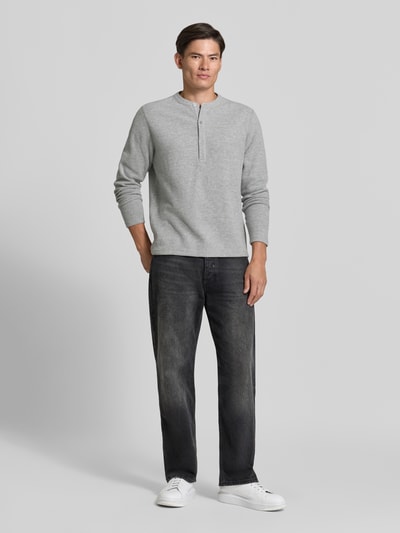 Męski model nosi bluzę Regular Fit Sweatshirt mit Baumwoll-Anteil Model 'MALIOR' od DRYKORN, Mieszanka materiałów z mieszanką bawełny, krój regular fit, zapięcie na guzik, długość tyłu w rozmiarze M: 63 cm, długość rękawów w rozmiarze M: 69 cm, jasnoszary materiał, czarne spodnie, białe buty, gładka tekstura, cała sylwetka z przodu