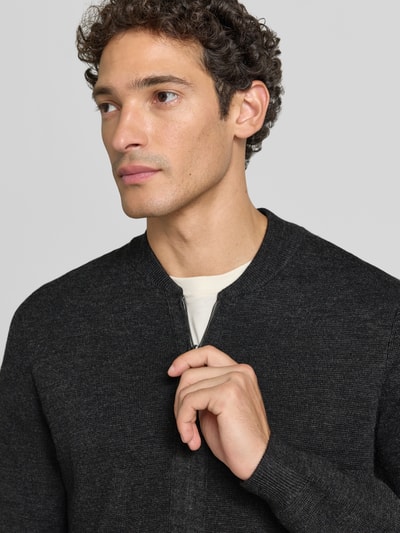Männermodel trägt Slim Fit Strickjacke aus Baumwoll-Mix mit Stehkragen von Christian Berg Men, dunkler Farbton, Nahaufnahme Oberkörper.