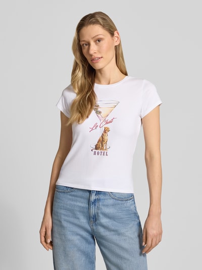 Frauenmodel trägt T-Shirt mit Label-Detail Modell 'LEOPARDTINI' von Guess, weiß, körpernah, Rundhalsausschnitt, Baumwoll-Elasthan-Mix, Ganzkörperansicht von vorne