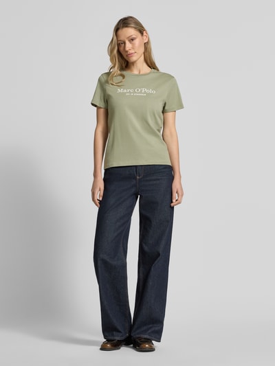 Vrouwenmodel draagt Regular Fit T-Shirt uit pure katoen van Marc O'Polo, effen design, korte mouwen, labelprint, ronde hals, Ganzkörperaanzicht van voren.