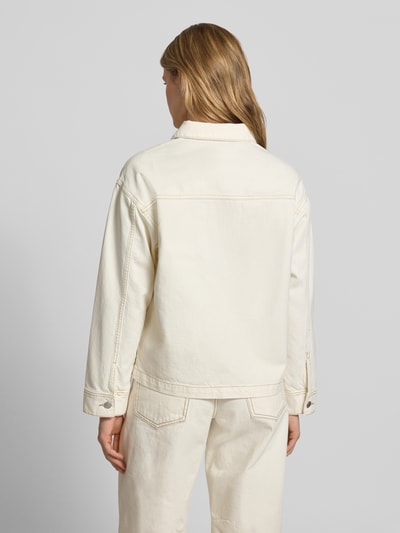 Frauenmodel trägt Jeansjacke mit Eingrifftaschen Modell 'RACHEL' von JJXX aus Reine Baumwolle, Straight Fit, Rückenansicht, Ganzkörperansicht Rückansicht. Schulterbreite 52 cm, Rückenlänge 61 cm, Brustweite 51 cm, Ärmellänge 54 cm, Farbe Creme, sichtbare Textur durch Nähte und Knopfleiste.