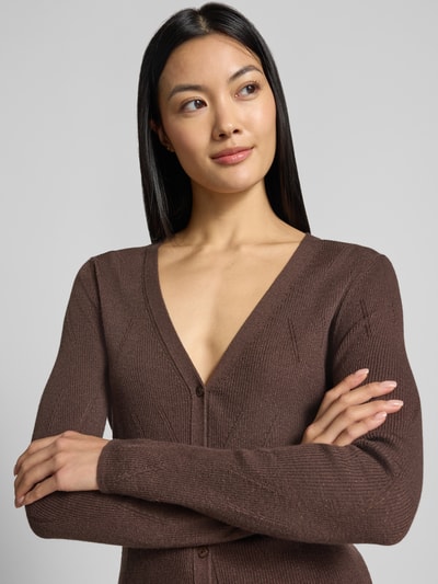 Frauenmodel trägt Cardigan in Strick-Optik mit Baumwoll-Anteil von Marc Cain in Braun, taillierte Passform, Nahaufnahme Oberkörper.