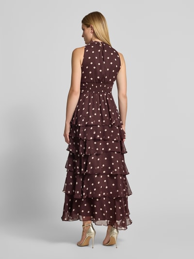 Frauenmodel trägt Abendkleid mit Rüschenbesatz Modell 'Marli' von Neo Noir in Braun mit weißen Punkten und taillierter Passform, Ganzkörperansicht Rückansicht.