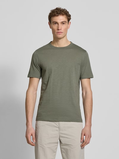 Männermodel trägt Regular Fit T-Shirt aus reiner Baumwolle Modell 'TEGOOD' von BOSS Orange in Oliv, unifarben, Ganzkörperansicht von vorne.