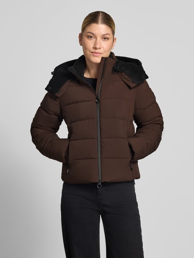 Frauenmodel trägt Jacke mit Daumenloch und Kapuze von NAUTGÅRD in Dunkelbraun, glattes Material, sichtbare Reißverschlüsse, Ganzkörperansicht von vorne, gerader Schnitt, Kapuze, seitliche Reißverschlusstaschen, gestrickte Ärmelabschlüsse, Rückenlänge 58 cm, Schulterbreite 40 cm, Brustweite 48 cm, Ärmellänge 65 cm.