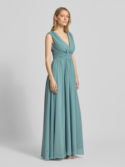 Frauenmodel trägt Maxikleid mit Taillenband und Drapierungen von TROYDEN COLLECTION aus Chiffon, Taillierter Schnitt, V-Ausschnitt, Ganzkörperansicht von vorne. Rückenlänge bei Größe 36: 133 cm, Brustweite bei Größe 36: 32 cm.