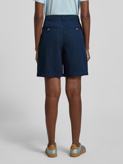 Vrouwenmodel draagt Regular Fit Chino-Shorts uit mix van katoen en lyocell van Tommy Hilfiger, look: effen, regular fit, logostitching, knoop- en ritssluiting, steekzakken zijkant, achterzak, ganzekörperaanzicht achteraan.
