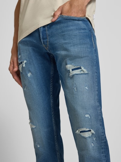 Männermodel trägt Straight Fit Jeans im Destroyed-Look Modell 'Grover' von Replay, Baumwoll-Mix, blauer Denim, Nahaufnahme Oberkörper.