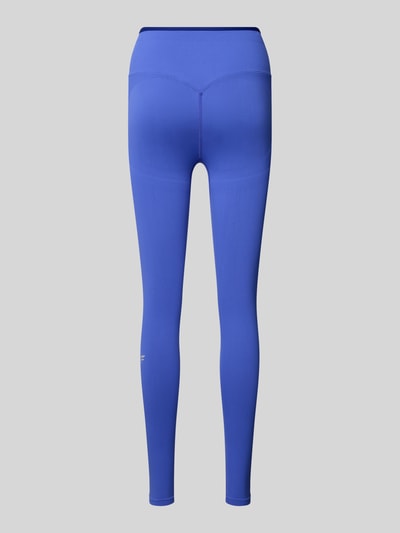 Frauenmodel trägt Leggings mit elastischem Bund und Label-Detail von Fabletics, körpernahe Passform, glatter Material-Mix, Ganzkörperansicht Rückansicht