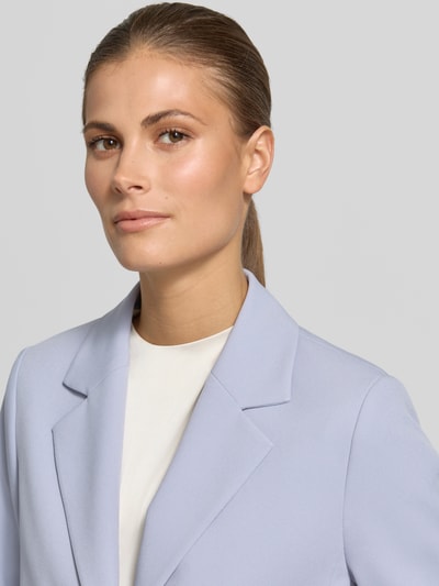 Kobieta nosi Regular Fit Kurzblazer mit 1-Knopf-Verschluss von s.Oliver BLACK LABEL, efekt: jednolity kolor, kołnierz z połami, krój regular fit, zapięcie na 1 guzik, długi rękaw, zakończenie rękawów: z rozcięciem. Zbliżenie na górną część ciała.