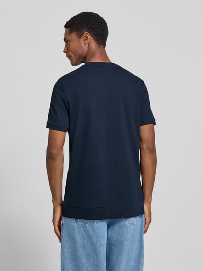 Männermodel trägt Regular Fit T-Shirt aus Baumwoll-Mix von s.Oliver RED LABEL in Dunkelblau, glatte Struktur, Ganzkörperansicht Rückansicht.