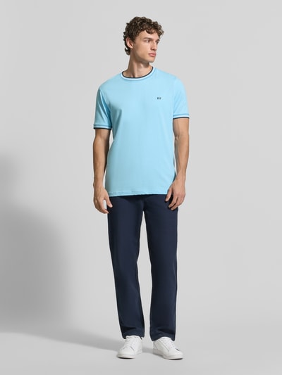 Männermodel trägt T-Shirt mit Kontraststreifen und Rundhalsausschnitt von Christian Berg Men, Baumwoll-Elasthan-Mix, Regular-Fit, hellblau mit dunklen Details, Rückenlänge bei Größe M 71 cm, Ganzkörperansicht von vorne.