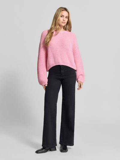 Vrouwenmodel draagt oversized gebreide pullover van linnenmix van American Vintage, roze, met lange mouwen, ronde hals, trendy, geribd, ruglengte maat XS/S: 56 cm, mouwlengte maat XS/S: 54 cm, volledige vooraanzicht