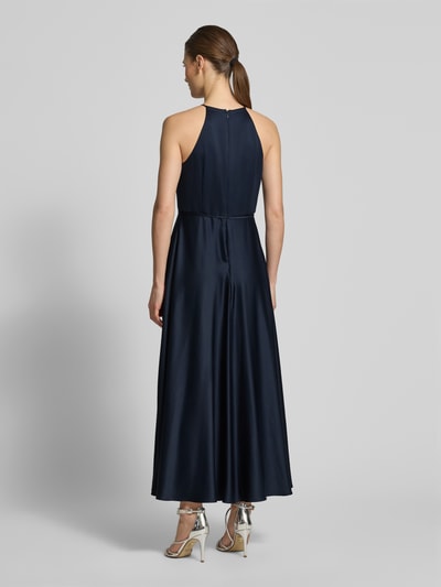 Frauenmodel trägt Cocktailkleid aus Satin mit Bindegürtel von Jake*s Cocktail in Dunkelblau, A-Linie, Neckholder, Ganzkörperansicht Rückansicht.