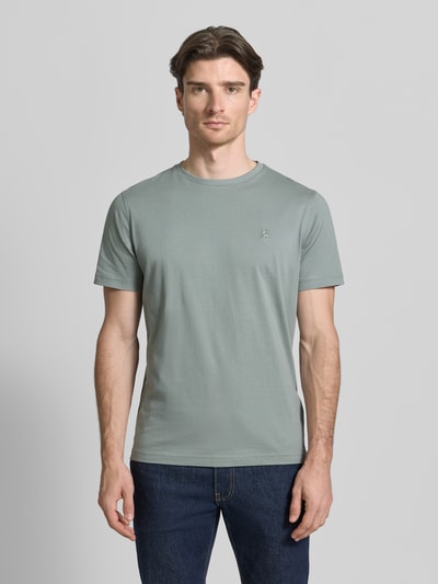 Męski model nosi T-Shirt mit Rundhalsausschnitt und Logo-Stitching od Lerros, bawełna, krój regular fit, kolor szary, widok całej sylwetki z przodu. Długość tyłu w rozmiarze M: 70 cm.
