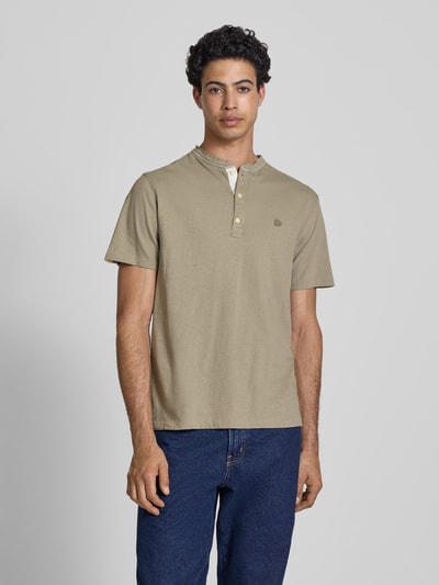Männermodel trägt T-Shirt mit kurzer Knopfleiste von Superdry in Beige, Baumwoll-Mix mit Leinen-Anteil, Regular Fit, Ganzkörperansicht von vorne.