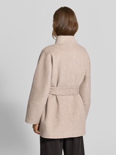 Frauenmodel trägt Mantel mit Woll-Anteil von MYON in Beige, Material-Mix, gerader Schnitt, Taillenband, Ganzkörperansicht Rückansicht.