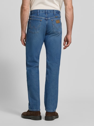 Männermodel trägt Regular Fit Bootcut Jeans aus reiner Baumwolle Modell '13MWZ Cowboy' von Wrangler in Blau, Ganzkörperansicht Rückansicht. Herren Straight Fit Jeans von Wrangler.