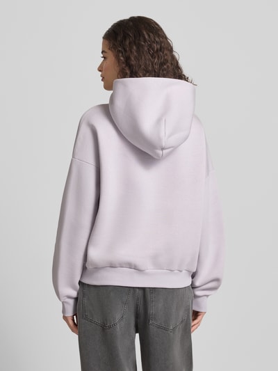 Frauenmodel trägt Relaxed Fit Sweatshirt mit Logo-Print von Review aus Baumwoll-Mix in hellem Flieder, elastische Abschlüsse, Ganzkörperansicht Rückansicht.