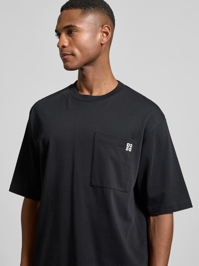 Männermodel trägt Loose Fit T-Shirt im 2er-Pack von Dsquared2 aus reiner Baumwolle mit Brusttasche und Label-Detail, Nahaufnahme Oberkörper.