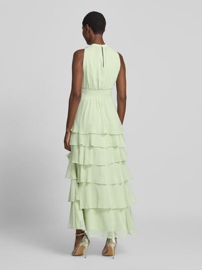 Frauenmodel trägt Abendkleid mit Volantsaum Modell 'MARLI' von Neo Noir in zartem Grün, Chiffon, Rückansicht Ganzkörperansicht.