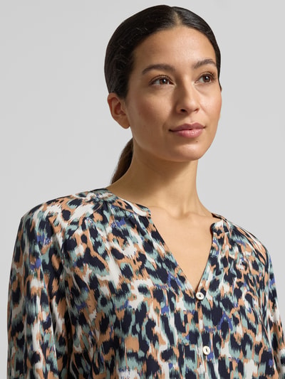 Frauenmodel trägt Blusenshirt aus reiner Viskose von Christian Berg Woman mit Allover-Animal-Muster, Nahaufnahme Oberkörper.
